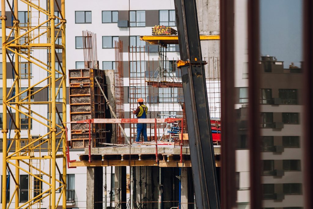 Workers engineers working at construction site and cranes on background of new building skyscrapers